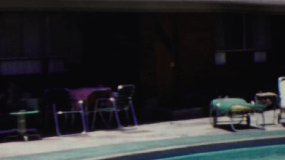 1949 Seaside, New Jersey poolside frame showing lounge chairs, small tables, and a shaded building facade in soft 8mm color.