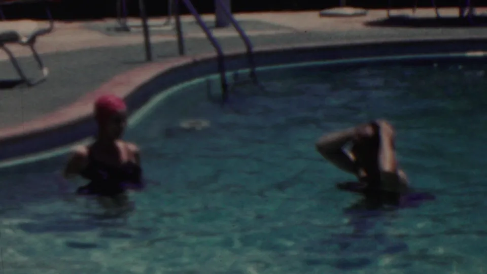 The 1949 Seaside, New Jersey home movie shows two women standing chest-deep in a swimming pool as one wears a pink cap and the other adjusts her hair.