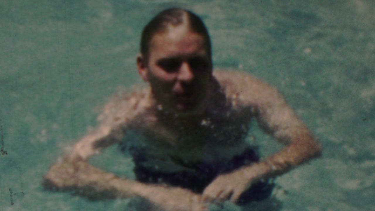 In metadata-supported 1949 Seaside, New Jersey footage, a man in dark swim trunks faces the camera while moving through a sunlit swimming pool.