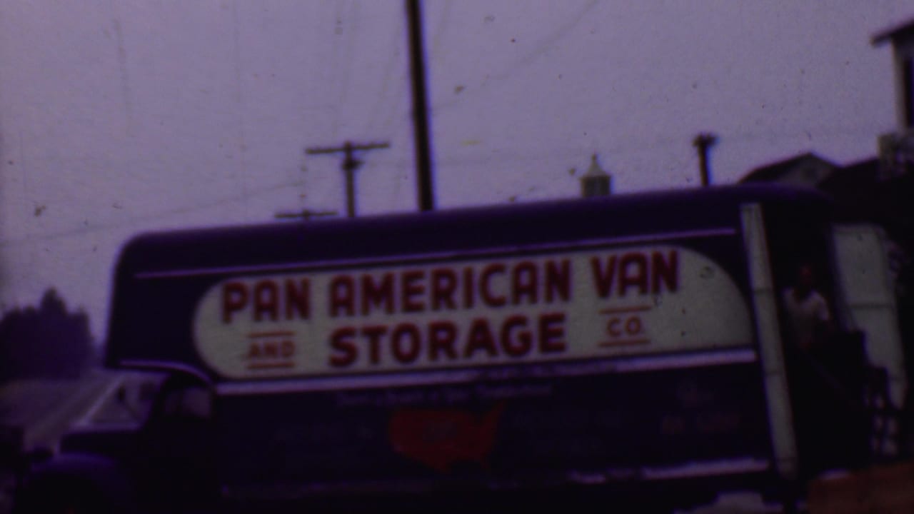 Pan American Van and Storage Co. truck side sign framed with utility poles and a building edge.