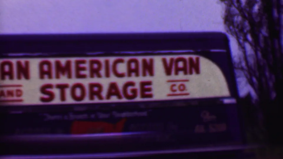 The truck's Pan American Van and Storage Co. lettering dominates the frame, with the dark vehicle body and a red map-shaped graphic below the sign.