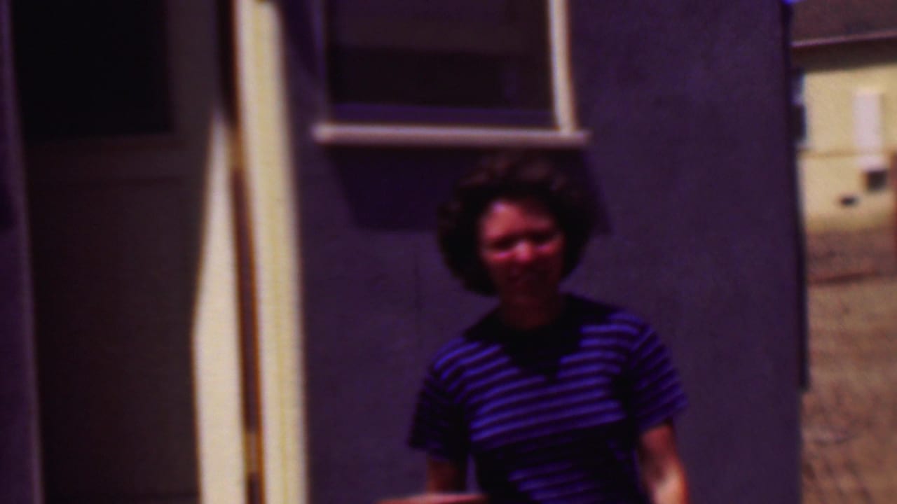 Woman in a striped shirt near a doorway on the right side of the frame.