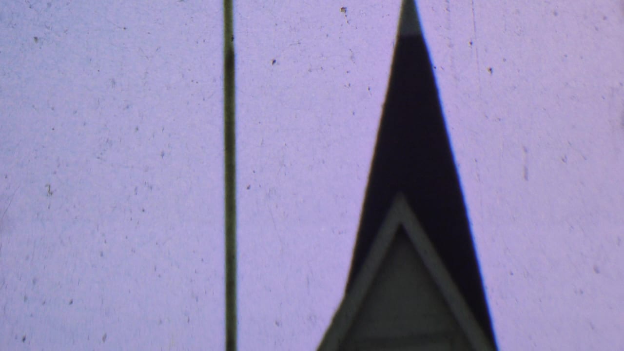 Dallas, Texas 1956 8mm frame with the dark upper church steeple, faint gable trim, a vertical pole, and visible film wear in the sky.