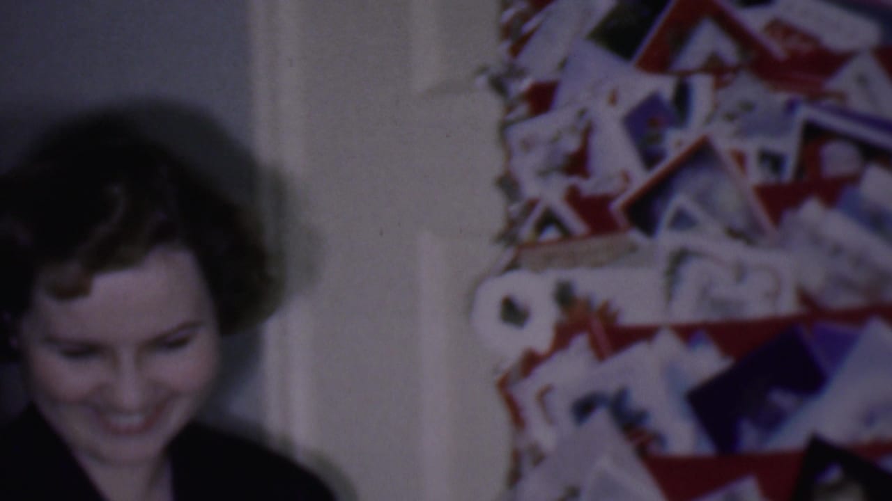 Smiling woman standing between holiday card displays on an interior door.