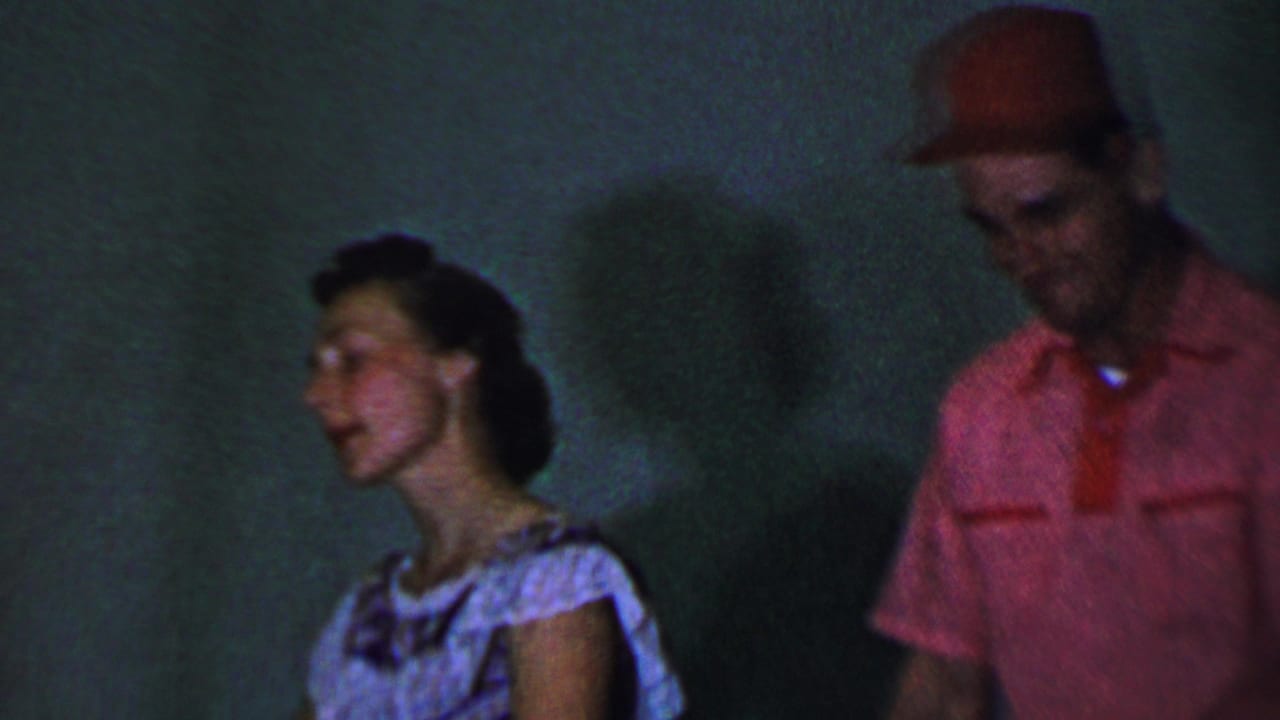 Young man and young woman standing in profile during a performance.