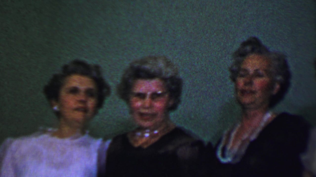 Several women stand in a row, some wearing pearls and formal dresses.