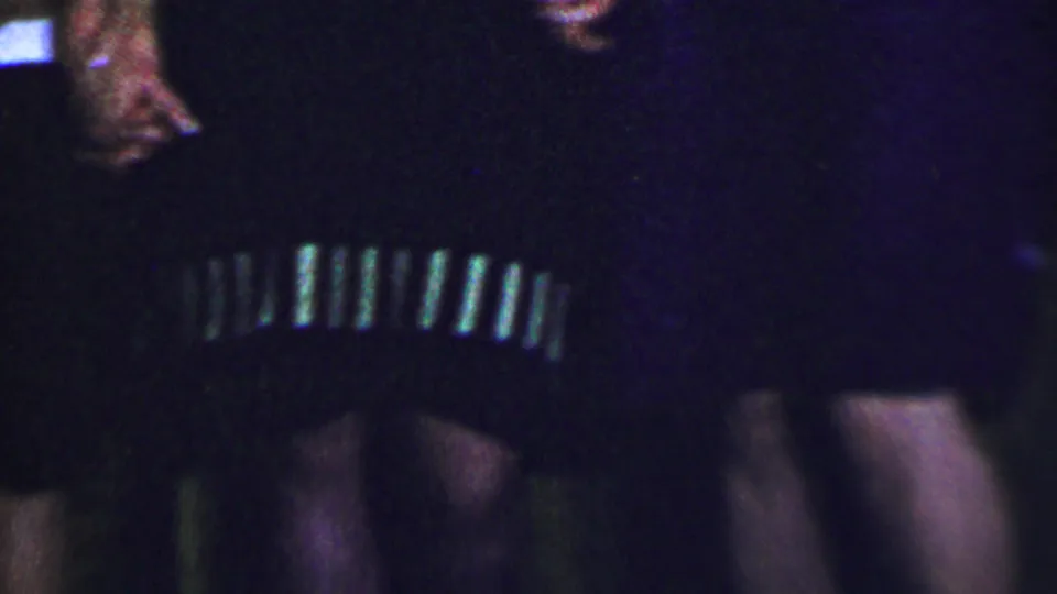 Cropped Dallas 1956 home-movie frame with women standing close together, including dark clothing with light trim and a red-and-white striped top.