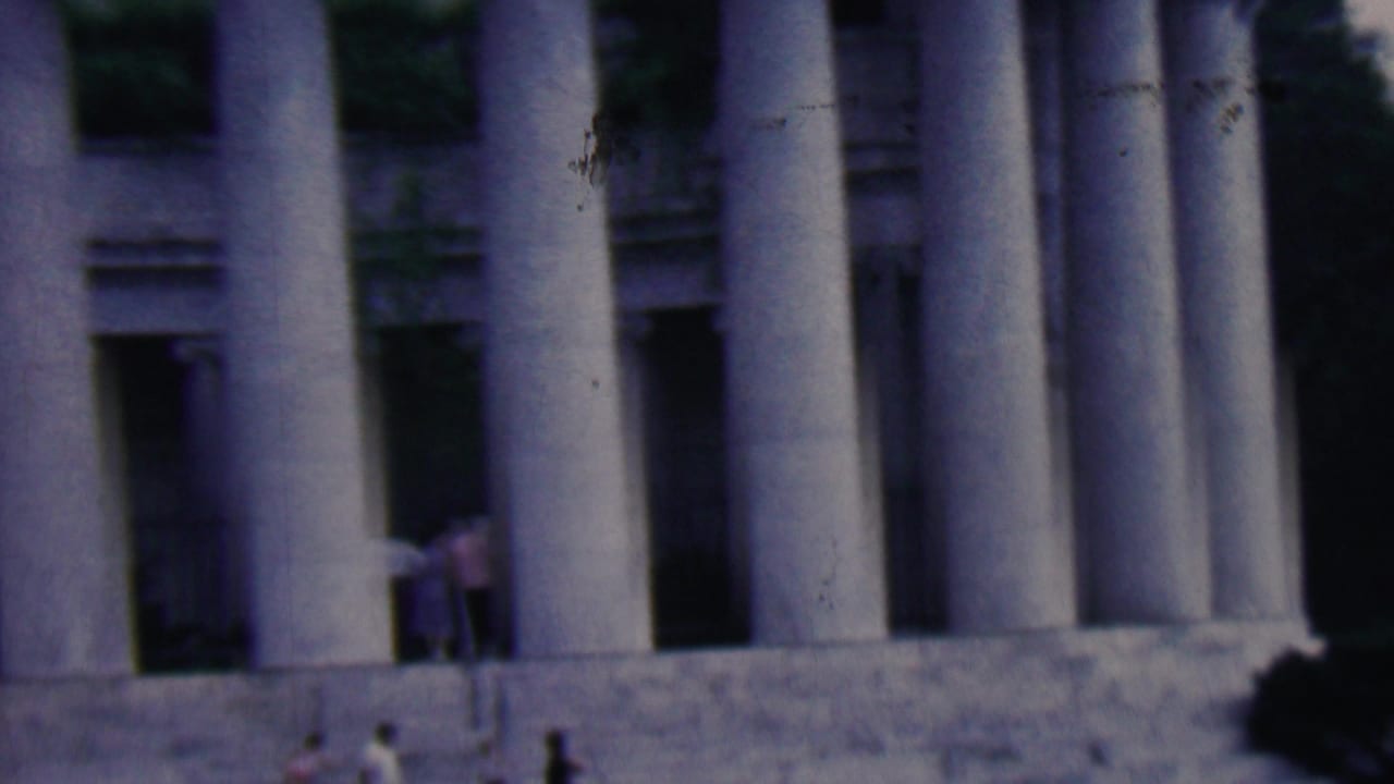1961 home-movie frame from Covington, Kentucky, showing small visitors near the steps and tall columns of a classical stone monument.