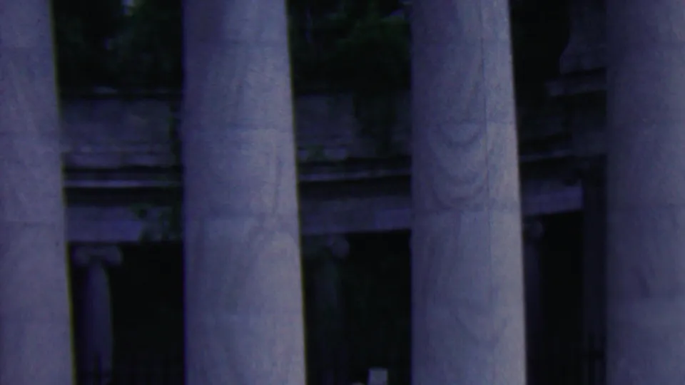 1961 Covington, Kentucky home-movie frame of closely spaced fluted columns, shadowed entrance areas, stone architectural detail, and cool underexposed color.