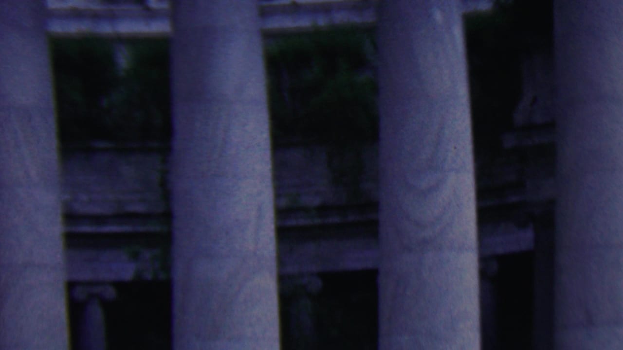 Classical stone columns and part of a monument facade in dim 8mm color.