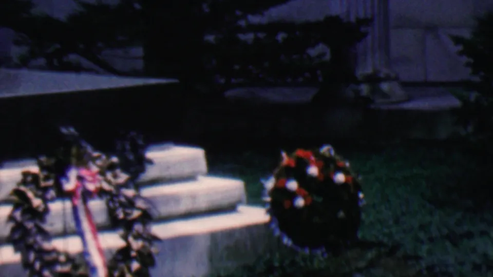 Covington, Kentucky 1961 frame showing memorial wreaths with red-white-and-blue ribbons arranged by stone steps below classical columns.