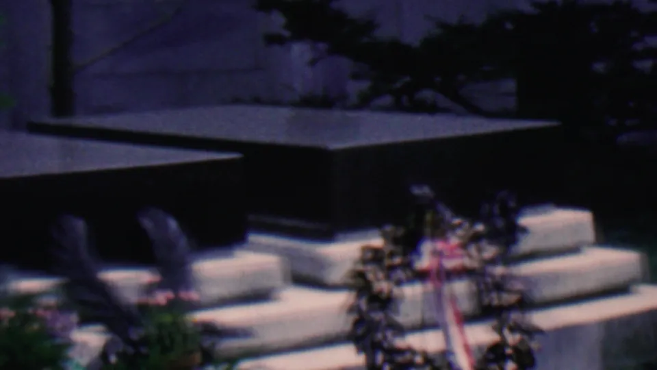 Covington, Kentucky, 1961 home-movie frame holding on floral wreaths and pale stone steps at an outdoor memorial monument.