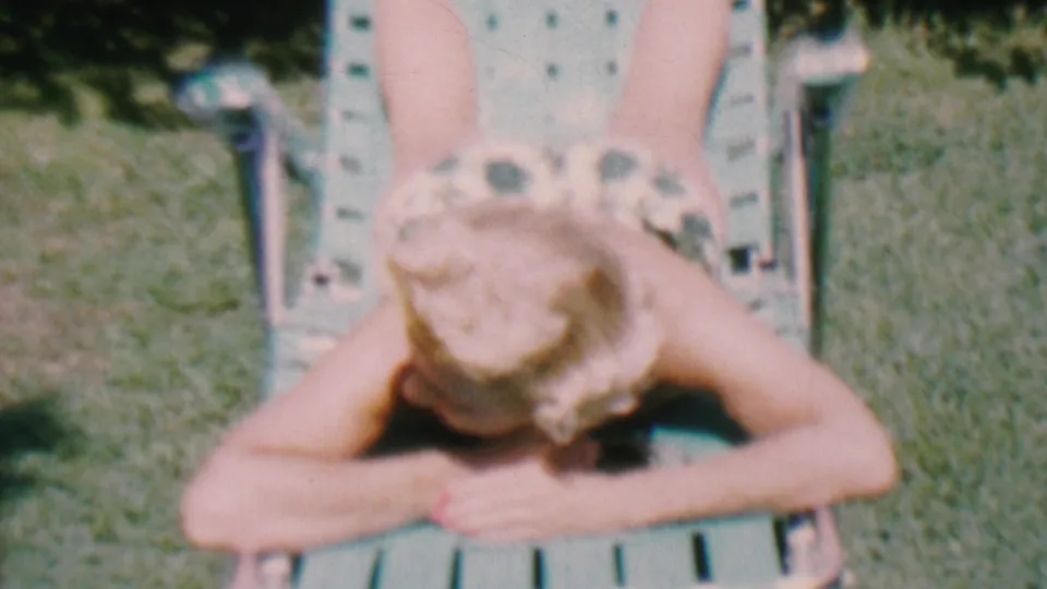 The final frame shows the woman resting on the green lawn chair in the sunlit Hatfield yard, with faded color and soft 8mm focus.