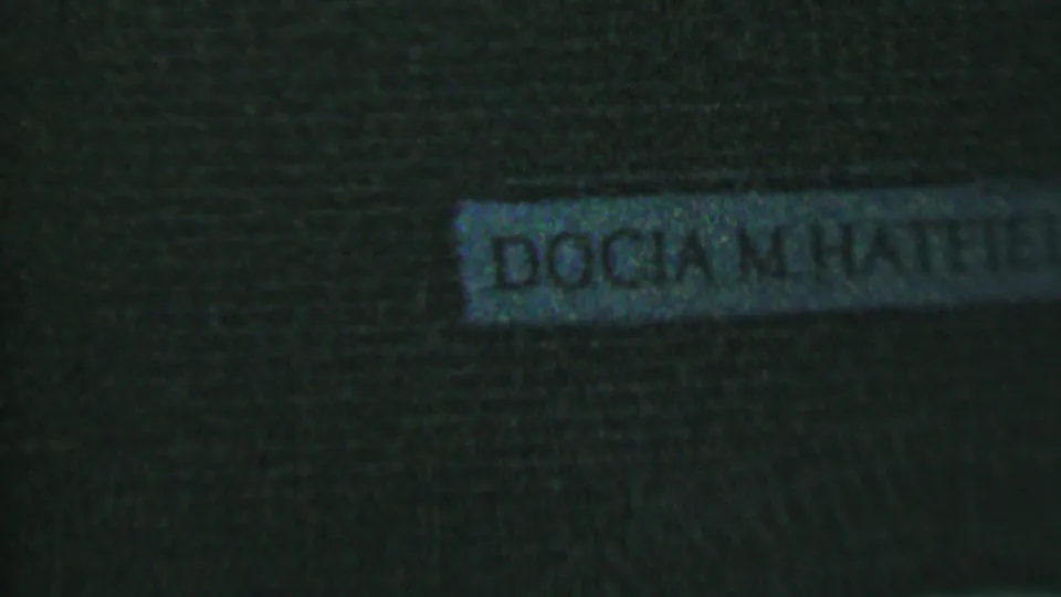 Low-light Hatfield, Pennsylvania frame showing a partial white nameplate on a dark brick wall, with the readable text DOCIA M. HATFIELD.