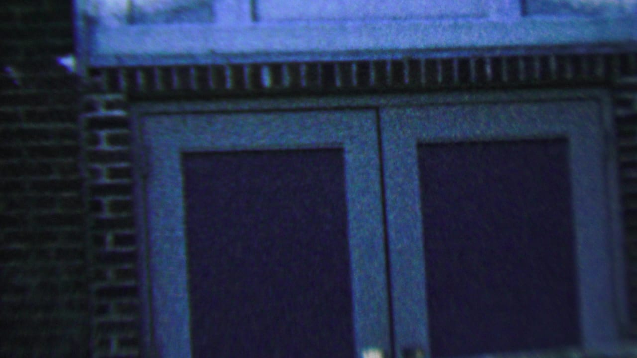 Brick facade with trim and two dark paneled doors.