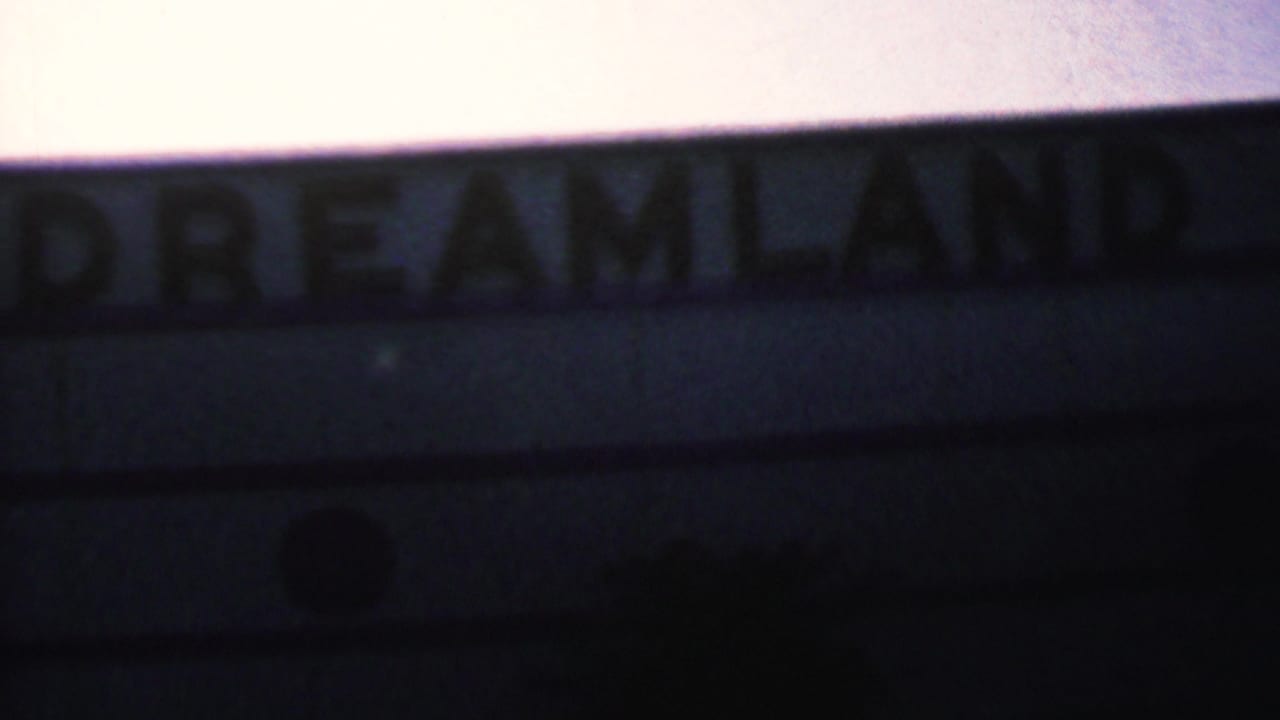 Blurred Dreamland lettering along a dark building edge at dusk.
