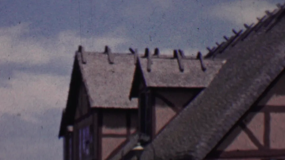 The camera pans across Solvang architecture, with a steep textured roof dominating the foreground and half-timbered building sections behind it.