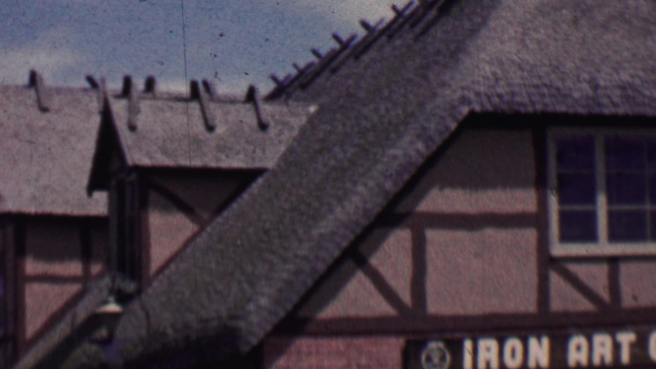 Upper storefront architecture with thatched roofs and part of a gift shop sign.