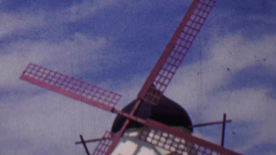 1955 Solvang frame with the windmill cropped close, emphasizing the red lattice blades, dark cap, white tower, and sky.