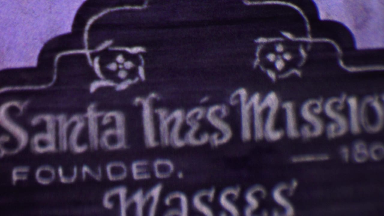 Upper section of the Santa Inés Mission sign with partial founded date text.