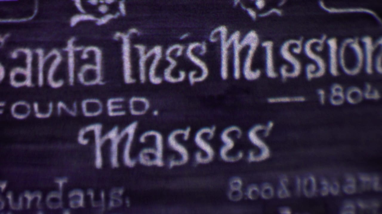 Mission sign close-up with founded date and mass lettering.