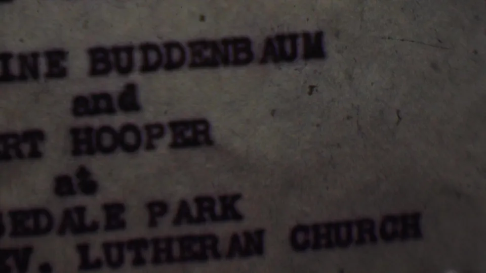 Blurred close-up of the typewritten invitation text, with Buddenbaum, Hooper, Edale Park, and Lutheran Church partially readable in the supplied Detroit wedding footage.