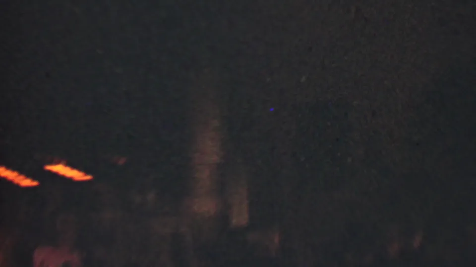 The final frame is mostly dark and soft, retaining partial silhouettes or blurred figures with small warm string lights visible, consistent with the nighttime wedding reception setting.