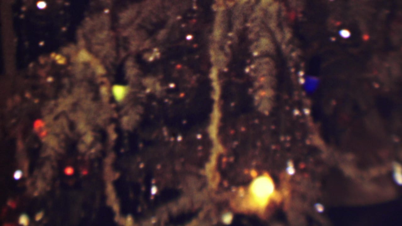 Dim close-up of textured material with colored lights and a bright yellow glow.