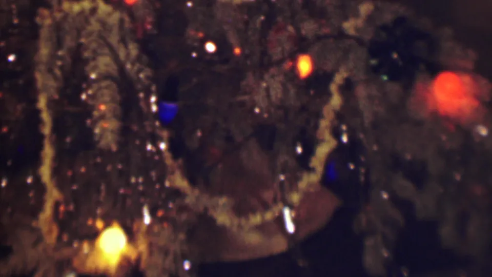 1963 Terre Haute 8mm frame showing reflective brown textured material with scattered blue, yellow, orange, and red lights, photographed close up in a dark private interior.