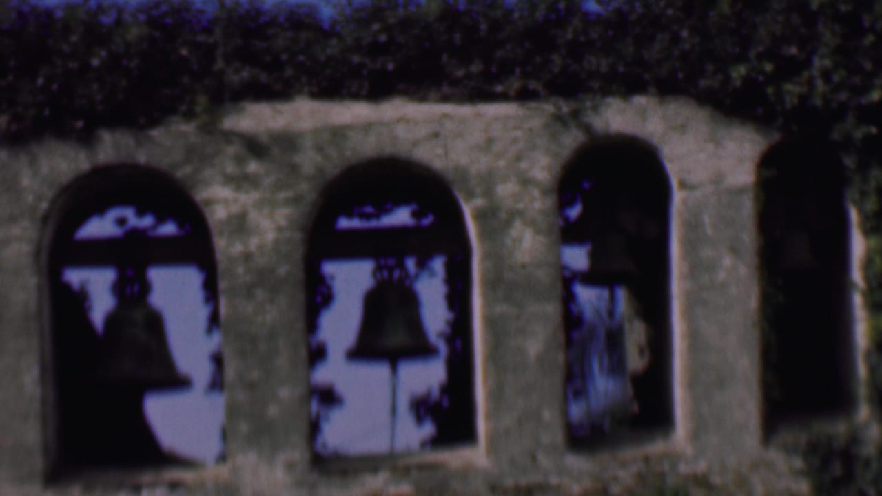 Stone bell tower arches with dark bell silhouettes and ivy along the top edge.