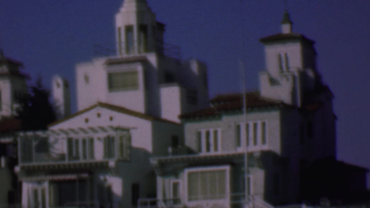Cluster of white stucco buildings with balconies and tower roofs.