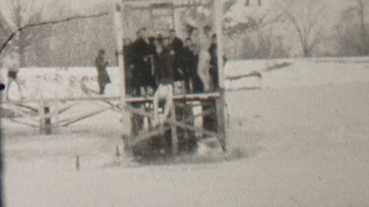 In Albany, New York, according to the clip metadata, several young people in winter coats stand on a wooden pier over icy water with snow and bare trees around them.