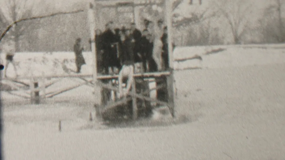 In Albany, New York, according to the clip metadata, several young people in winter coats stand on a wooden pier over icy water with snow and bare trees around them.