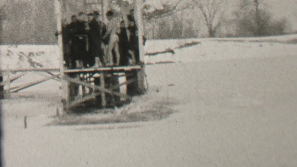 The final frame holds on the winter gathering at the pier, showing bundled figures, the icy water below, and snow-covered terrain in the Albany, New York clip.