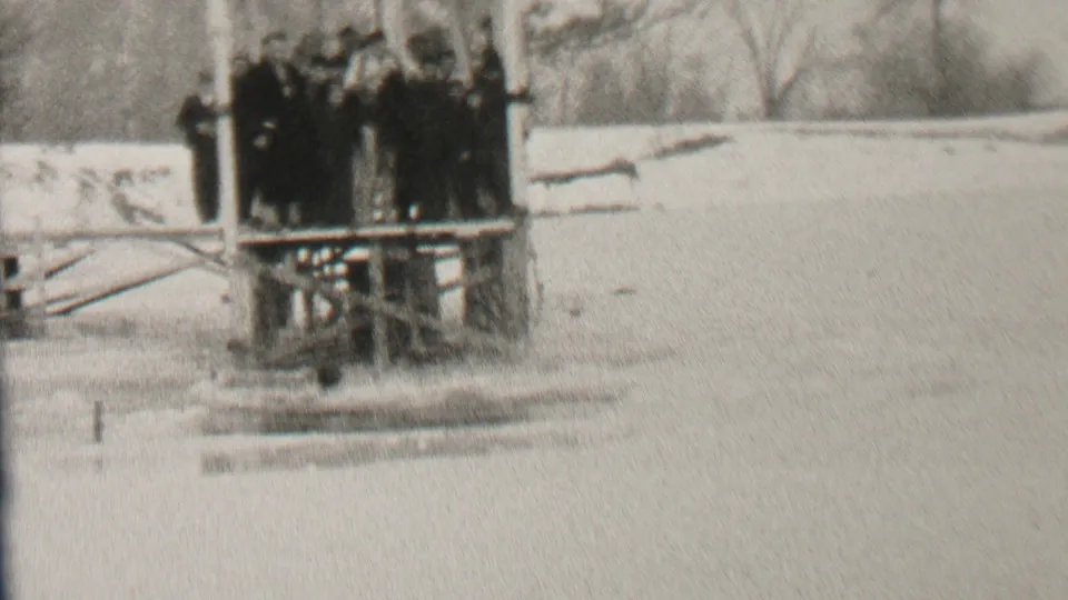 The final frame shows the group still gathered on the dock in the Albany winter setting, with disturbed water or splash marks visible below the platform.