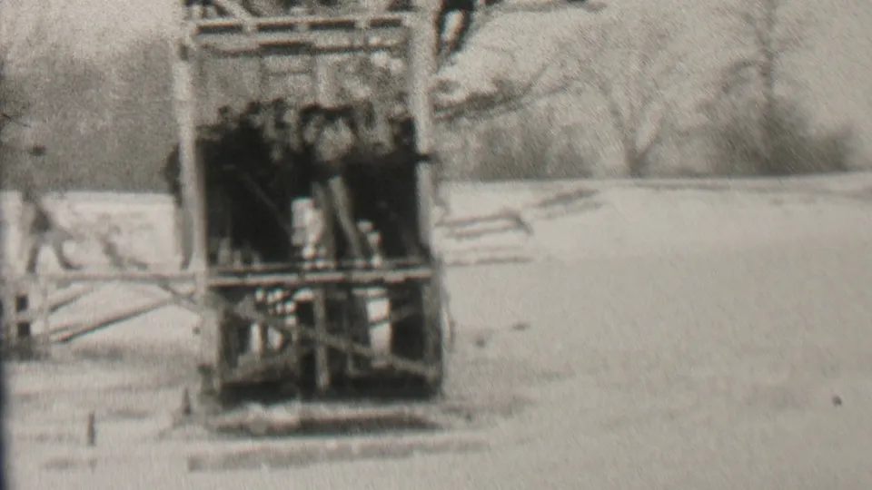 A closer view shows bundled spectators and a figure on the wooden structure before the icy plunge in Albany, New York archival footage from 1937.