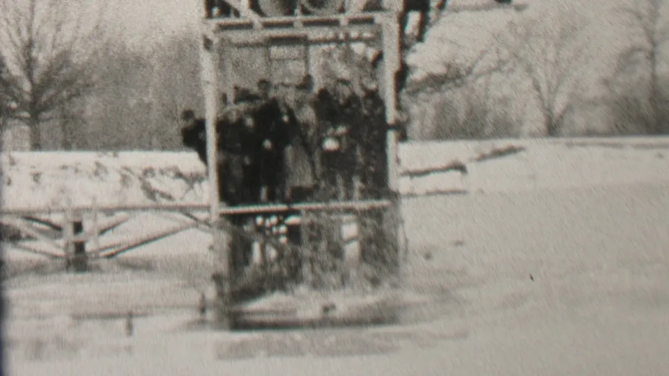 The closing frame shows the swim team grouped tightly in a wooden structure on the frozen lake, with bare trees and pale snow behind them in Albany.
