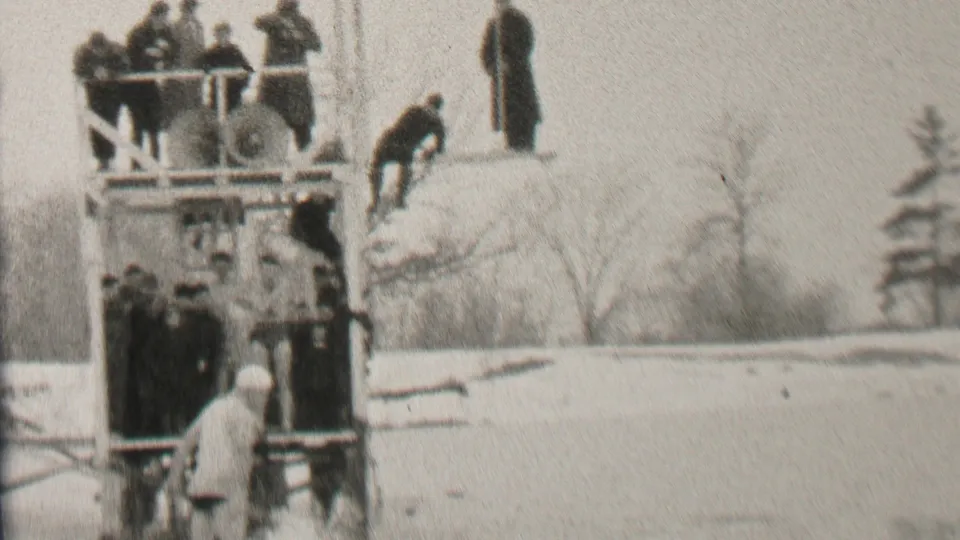 A lightly dressed participant stands near the base of the wooden platform, contrasting with bundled spectators above and the snow-covered 1937 Albany winter setting.