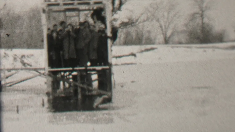 The final frame shows the same Albany winter platform with bundled people watching from above the ice in grainy black-and-white 8mm footage.