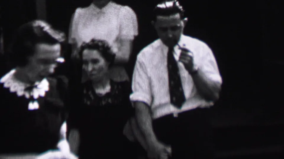 Albany, New York, 1937 frame showing a pipe-smoking man in a white shirt and tie beside women in period blouses and dark dresses.