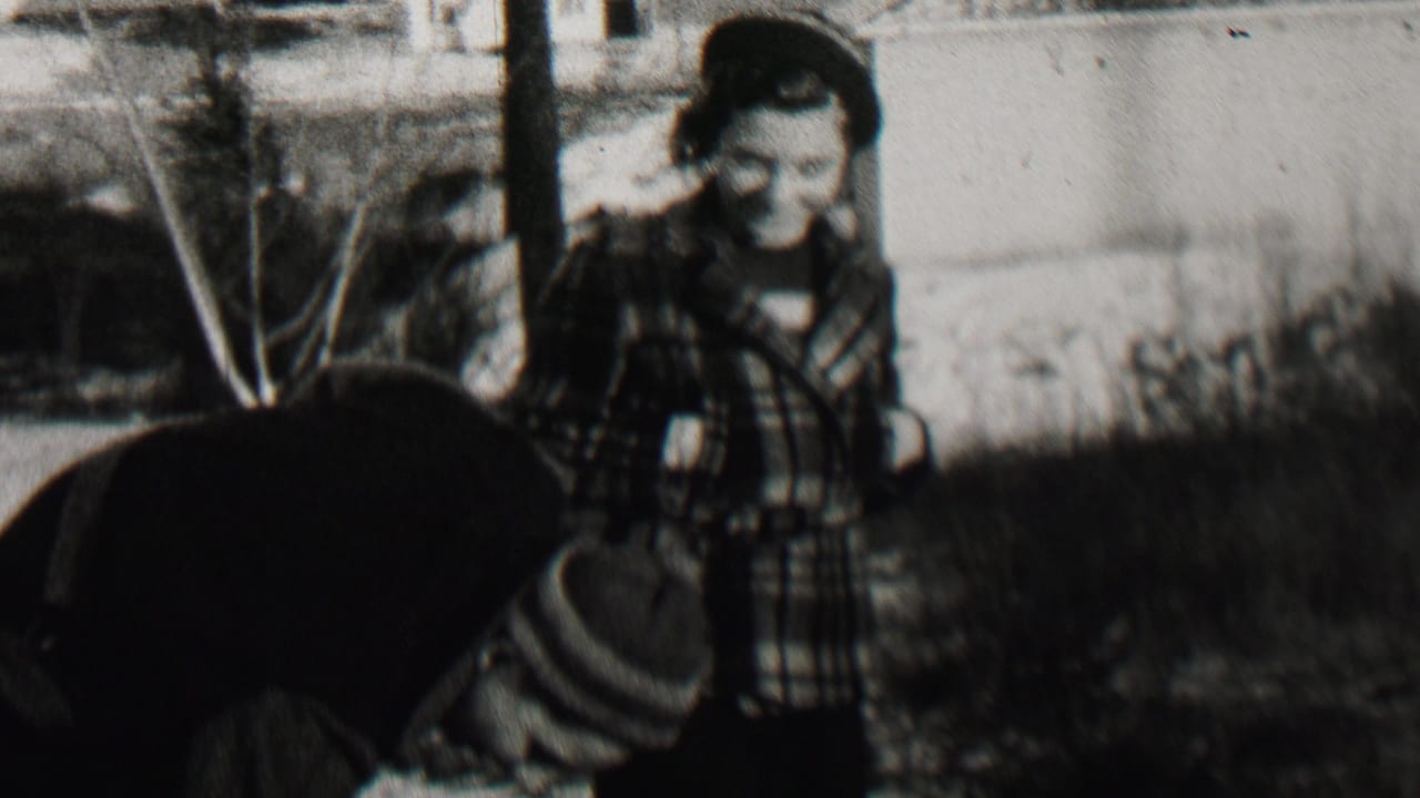 In Beachwood, New Jersey home-movie footage from 1937, a woman in a plaid coat and hat stands outdoors on snow as another bundled person bends toward the ground.