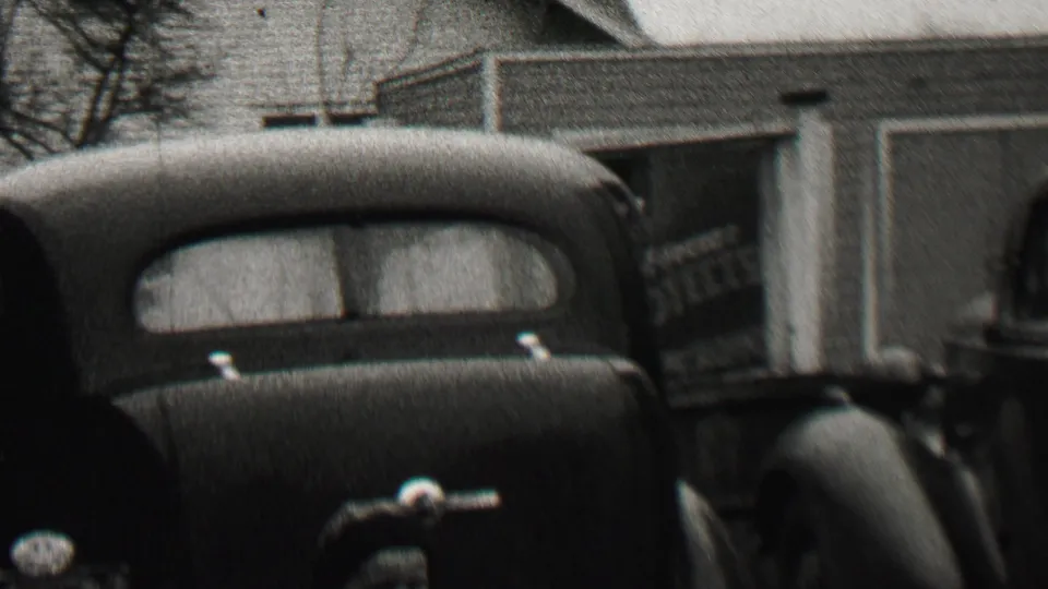 The final frame shifts toward a rounded vintage car parked near a building, while the man and woman remain partly visible at the edge of the 1937 Beachwood, New Jersey scene.