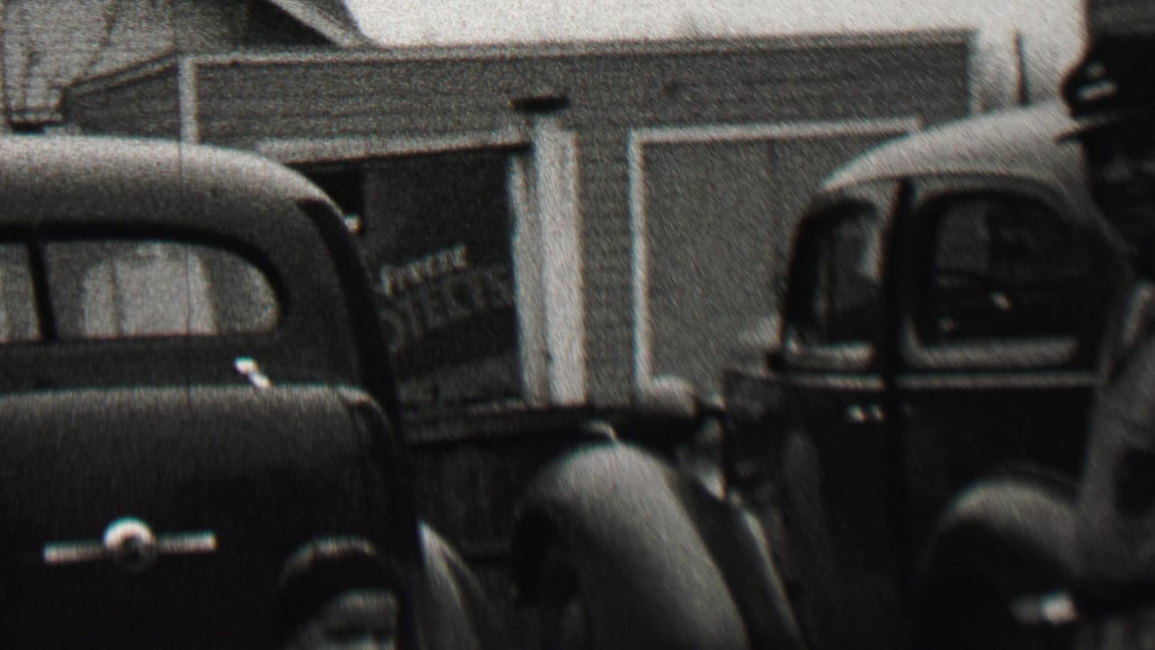 In the supplied 1937 Beachwood, New Jersey home-movie context, parked 1930s cars sit in front of a suburban house and garage while a man in a cap is partly visible.