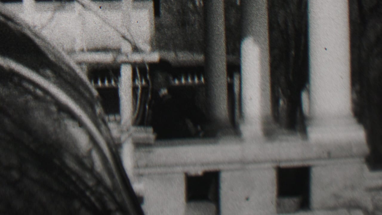 1937 Beachwood, New Jersey 8mm frame showing a close exterior view of a building entrance with columns, dark window openings, and bare tree branches.