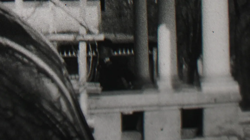 1937 Beachwood, New Jersey 8mm frame showing a close exterior view of a building entrance with columns, dark window openings, and bare tree branches.