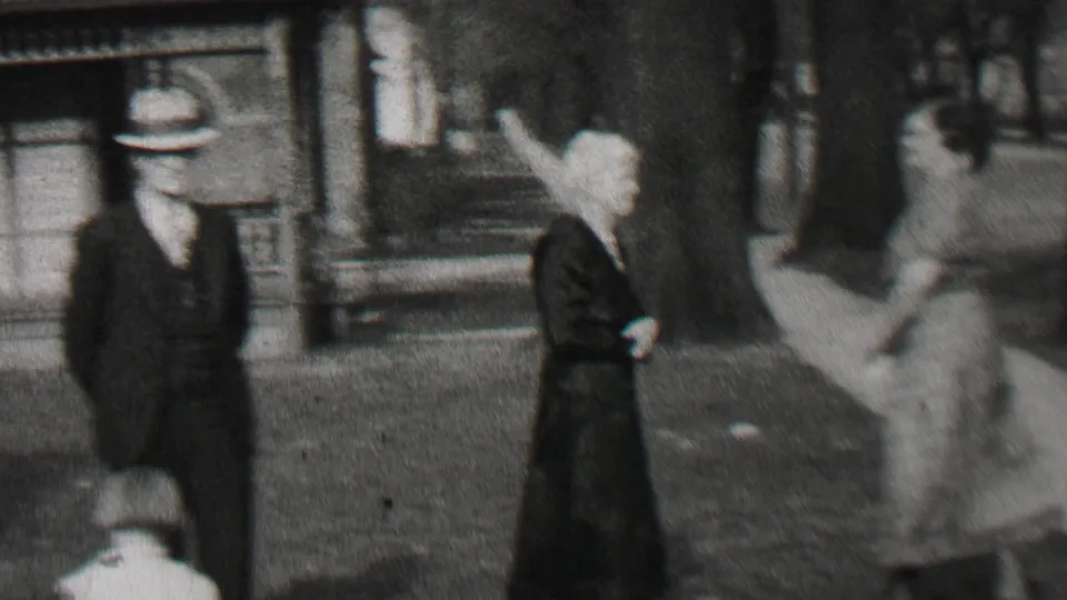 A suited man in a hat and women in period clothing appear in a brief Beachwood, New Jersey 1937 outdoor gathering, with motion blur from home-movie filming.