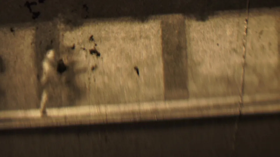 In this 1937 Beachwood, New Jersey 8mm frame, a small blurred running figure crosses a bright, textured surface beneath dark shadow bands.