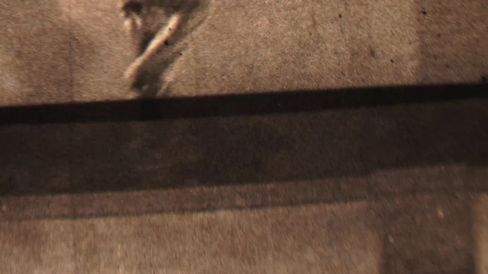 This 1937 Beachwood, New Jersey frame shows a partial blurred running figure near the left side, with a bright textured surface, dark lower shadow, and visible film grain.