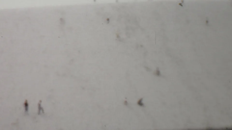 The final frame shows a small pair of distant people and other faint figures on a broad faded hillside in the supplied 1959 United States 8mm footage.