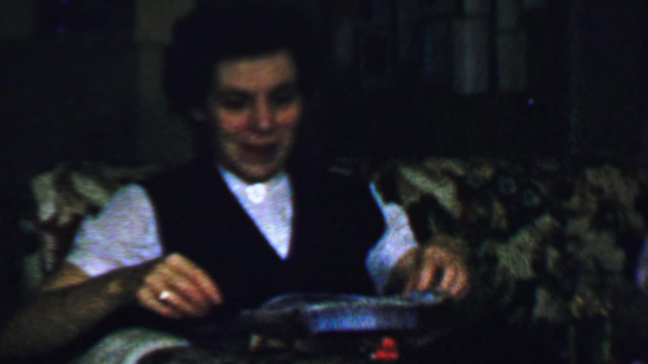 Woman smiles while handling a shallow tray or gift box on her lap.